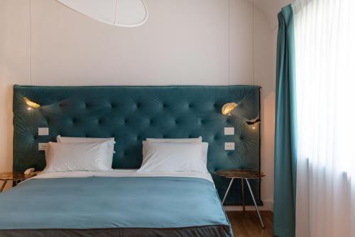 a bedroom with a large bed with a green headboard at Palazzo Martinelli in Sorrento