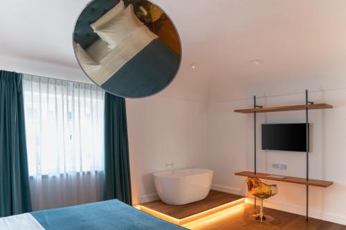 a bedroom with a bed and a tub and a television at Palazzo Martinelli in Sorrento