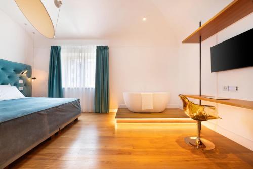a bedroom with a tub and a bed and a chair at Palazzo Martinelli in Sorrento