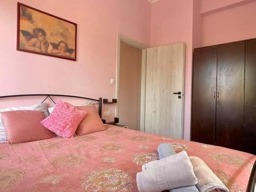a bedroom with a large bed with pink walls at Souda Bay in Souda