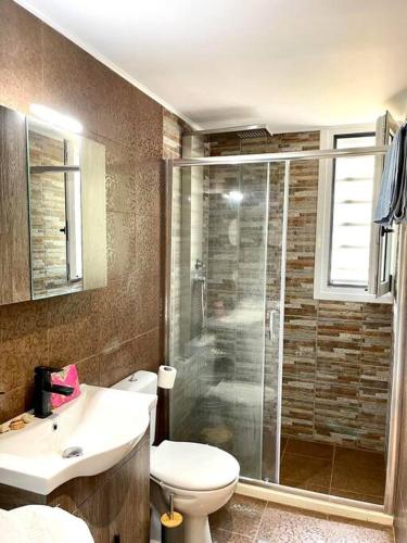 a bathroom with a shower and a toilet and a sink at Souda Bay in Souda