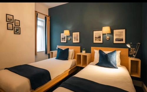 2 camas en una habitación con paredes azules en Celtic Lodge Guesthouse - Restaurant & Bar, en Dublín