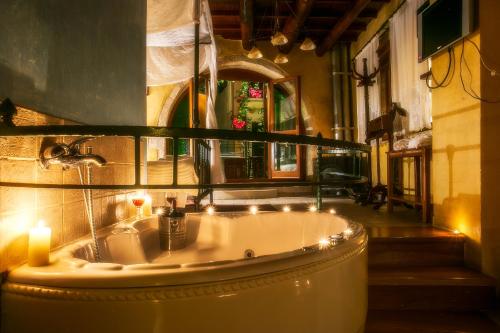 baño con bañera con velas y espejo en Ifigenia Traditional Rooms & Maisonettes, en La Canea