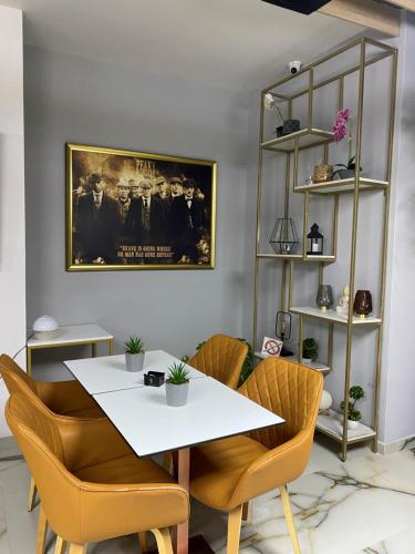 a dining room with a white table and chairs at Peaky Hotel in Durrës