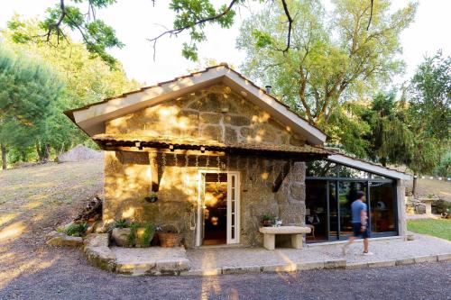 a small stone building with a man standing outside at Quinta Vale de Frades in Torrão