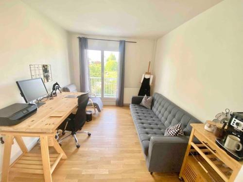 ein Büro mit einem Sofa, einem Schreibtisch und einem Tisch in der Unterkunft Appartement avec deux balcons in Magny-les-Hameaux