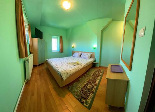 a small bedroom with a bed and a table at Casa Popa in Cârțișoara
