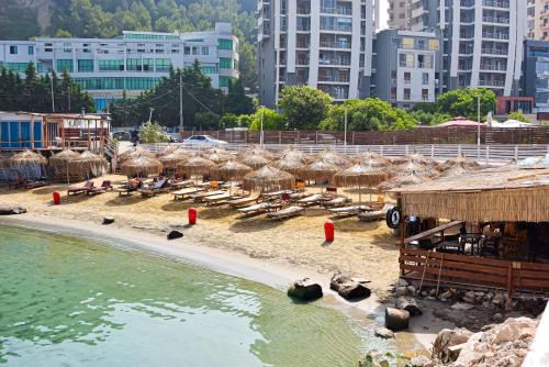 una spiaggia con ombrelloni e persone sdraiate sulla sabbia di Peaky Hotel a Durrës
