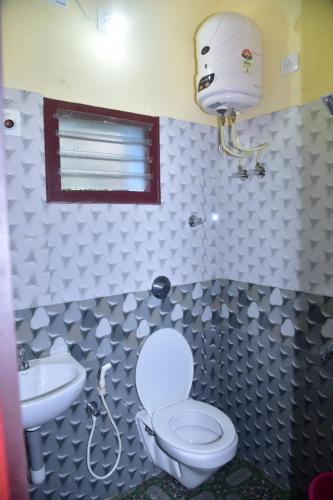 a bathroom with a toilet and a sink at Devatha Homestay, Guest House, Hotel,Dharmasthala-2 in Dharmastala