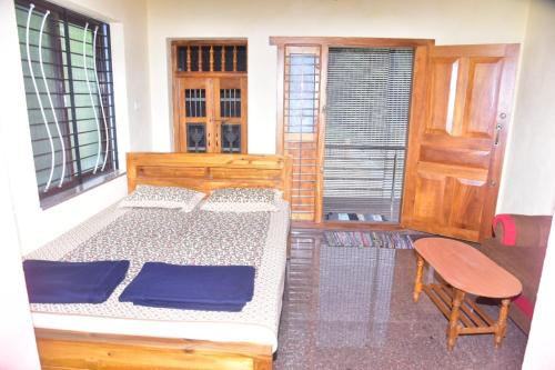 a bedroom with two beds and a chair and a window at Devatha Homestay, Guest House, Hotel,Dharmasthala-2 in Dharmastala
