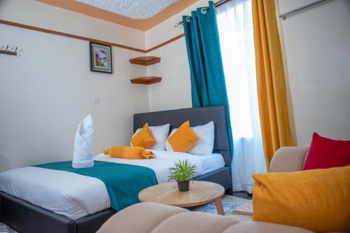 a hotel room with two beds and a couch at Nelly fully furnished studios in Naivasha