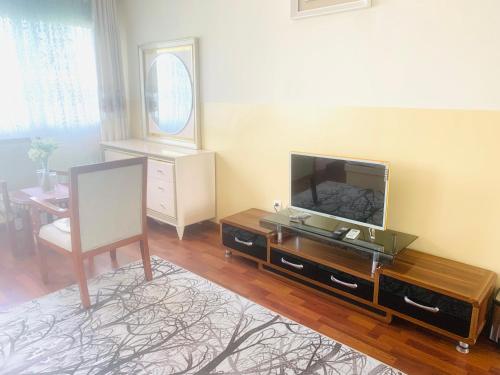 uma sala de estar com uma televisão de ecrã plano sobre uma mesa em Hôtel Sky blue Mada em Alasora