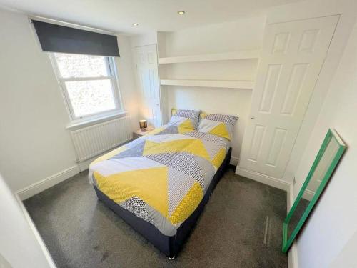 a bedroom with a bed in a room with a window at Spacious 1-bedroom Flat in Sutton (South London) in Sutton