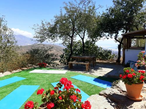 a garden with a picnic table and flowers on the grass at Cortijo Los Maximos in Turón