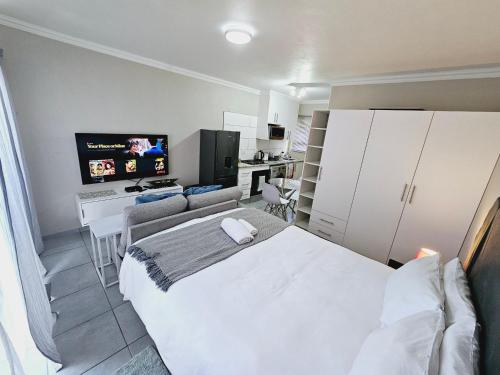 ein Krankenhauszimmer mit einem Bett und einem TV in der Unterkunft Quantum Heights - Studio Apartment in Fourways