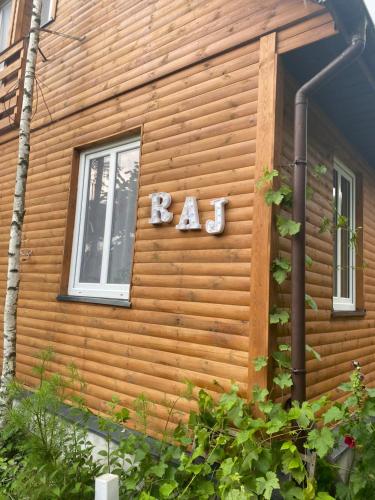 a log cabin with a ra sign on the side of it at Ozierański Raj "Pod rzeźbami" in Krynki