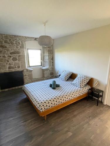 um quarto com uma cama e uma parede de pedra em Gîte La Morille em Ravel