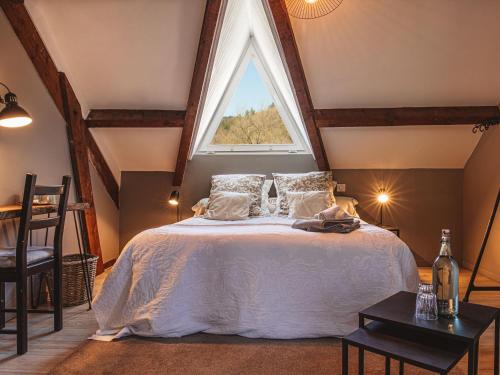 a bedroom with a bed with a large window at La Petite Auberge de Virginie in Bédouès