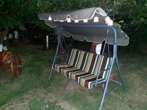 una sedia sotto un gazebo in un cortile di къща за гости Градина ad Aheloy
