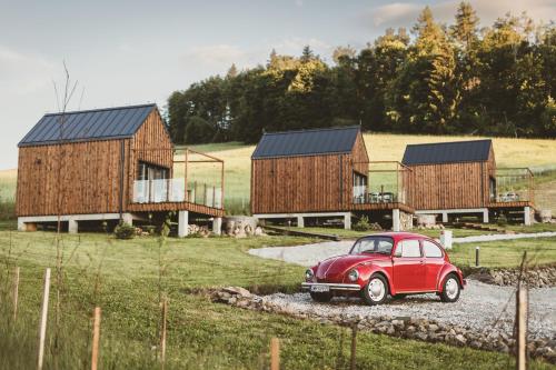 a red car parked in front of some houses at WymarzONE domki- z prywatnymi jacuzzi i kominkiem in Wieściszowice