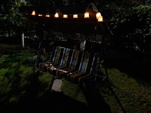 um banco de parque com luzes no escuro em къща за гости Градина em Aheloy