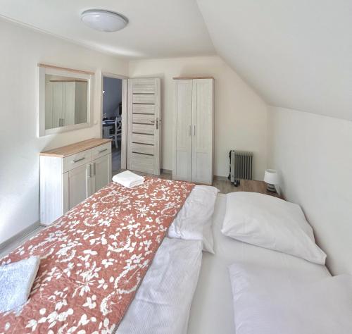 a bedroom with a bed with a red and white blanket at Apartamenty Golf Dyndeby in Neksø