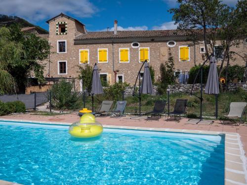un canard gonflable en caoutchouc dans une piscine en face d'une maison dans l'établissement La Maison des Hôtes, à La Motte-du-Caire