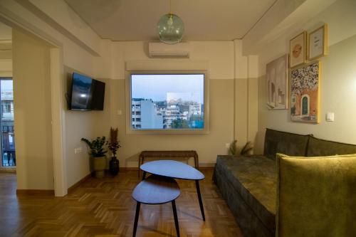 a living room with a couch and a table and a window at Acropolis View - 500m Metro - At Historical Center in Athens