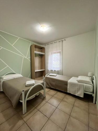 una camera con due letti e una finestra di appartamento valmontone a Valmontone