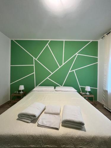 una camera da letto con un grande letto con una parete verde di appartamento valmontone a Valmontone