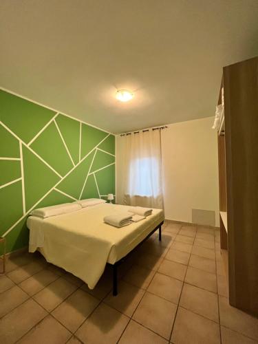 a bedroom with a bed and a green wall at appartamento valmontone in Valmontone