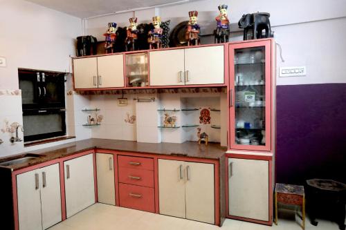 a kitchen with white cabinets and a red and white refrigerator at Banaji Heritage Haveli in Jodhpur