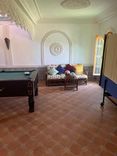 a living room with a couch and a pool table at Atlantic Vacation villa in Dar Oulad Hajj Kassem