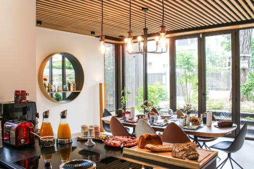 - une salle à manger avec une table, des chaises et un miroir dans l'établissement L'Escale Donatienne, à Nantes