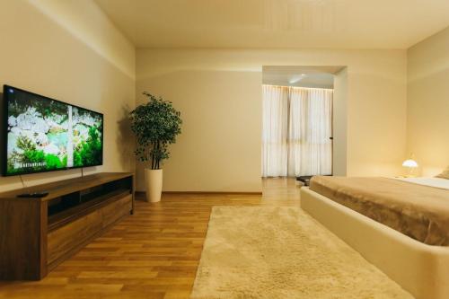 1 dormitorio con 1 cama y TV de pantalla plana en Atlant luxury Big Family Apart on Golovna з двома окремими спальнями навпроти ТЦ ДЕПОТ БЕЗКОНТАКТНЕ ЗАСЕЛЕННЯ, en Chernivtsi