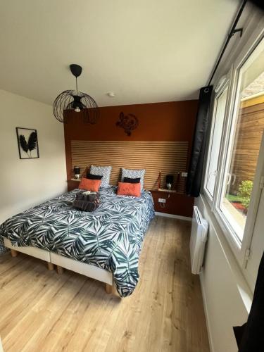 una camera da letto con un letto con cuscini arancioni di Beau Loft room proche mont saint Michel jaccuzi illimité en plein centre Avranches ad Avranches