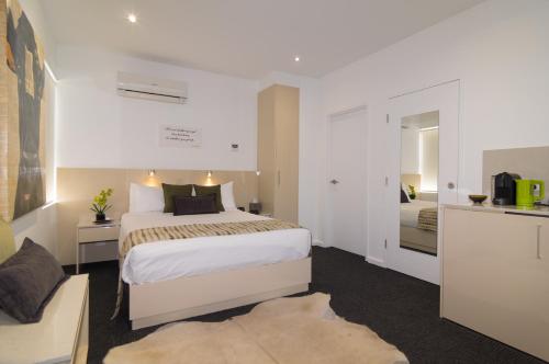 
a hotel room with a bed and a dresser at North Adelaide Boutique Stays Accommodation in Adelaide
