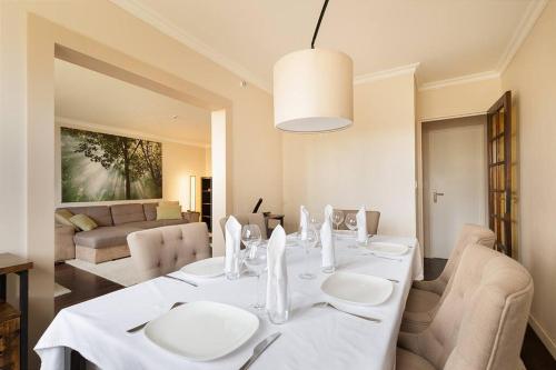 une salle à manger avec une table et des chaises blanches dans l'établissement Magnifique appartement entre Disneyland et Paris 3 Chambres, à Neuilly-sur-Marne