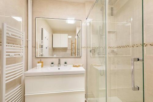 a bathroom with a sink and a glass shower at Magnifique appartement entre Disneyland et Paris 3 Chambres in Neuilly-sur-Marne