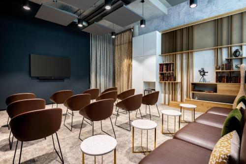 a waiting room with a group of chairs and a tv at Residence Inn by Marriott Essen City in Essen