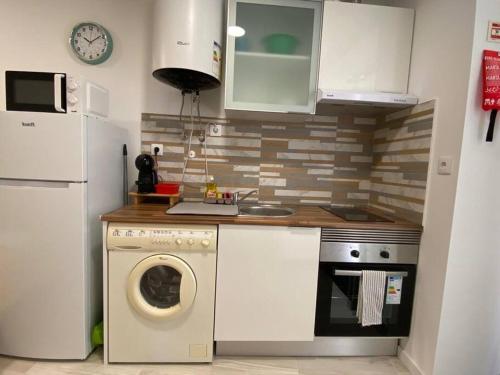 a kitchen with a washing machine and a refrigerator at Holiday Setúbal Loft in Setúbal