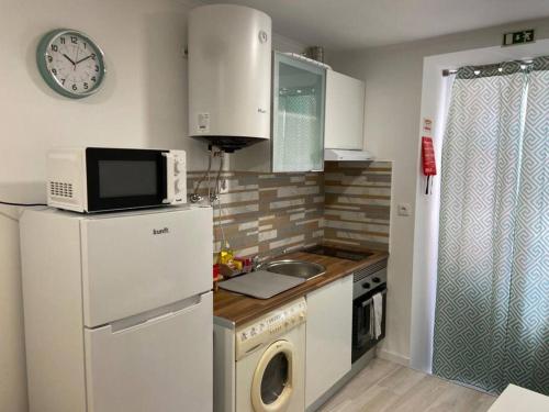 a kitchen with a white refrigerator and a microwave at Holiday Setúbal Loft in Setúbal