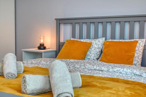a bedroom with a large bed with orange and gray pillows at Apartament Wiesental in Polanica-Zdrój