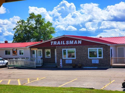 a train station building with a red roof at Trailsman Lodge in Baddeck