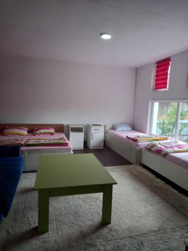 um quarto com duas camas e uma mesa verde em Arthur 1 em Brcko