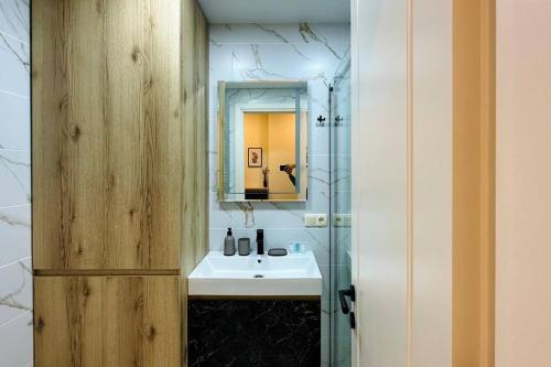 a bathroom with a sink and a mirror at Your Corner in Batumi ! in Batumi