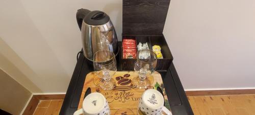 a table with a coffee maker and glasses on it at Pyramids Kingdom in Cairo