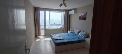 a small bedroom with a bed and a window at SEA VIEW FLORA in Burgas City