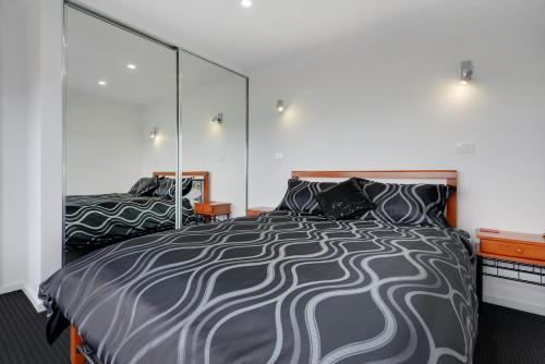 Un pat sau paturi într-o cameră la Burnie by the Bay Apartments