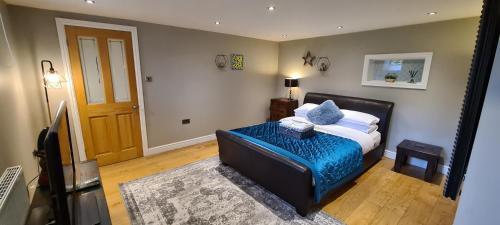 um quarto com uma cama com um cobertor azul em The School House, Sowood, Halifax em Halifax